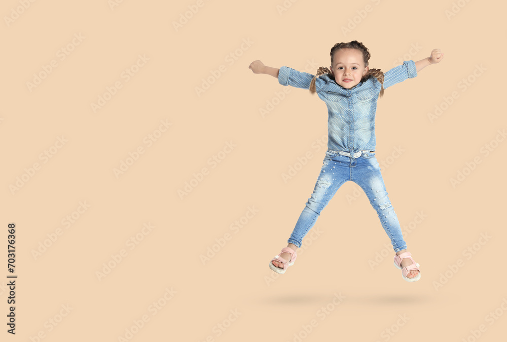 Cute girl jumping on beige background, space for text Cute girl jumping on beige background, space for text