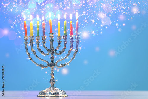 Hanukkah celebration. Menorah with burning candles on table against light blue background, space for text