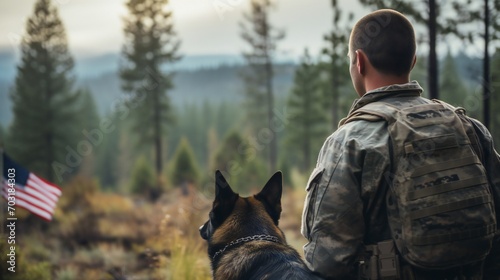 Landscape shot featuring the back of a military man and his service German Shepherd, symbolizing unity and patriotism against the US flag on Veterans Day.
