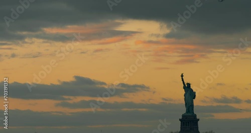 Silhouetted Statue of Liberty in Front of Orange Sunset