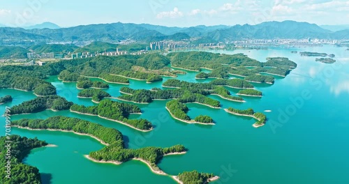 Aerial footage of Xin'anjiang Reservoir natural landscape in Hangzhou. Green islands and mountains with clear lake water. Drone shooting forward.