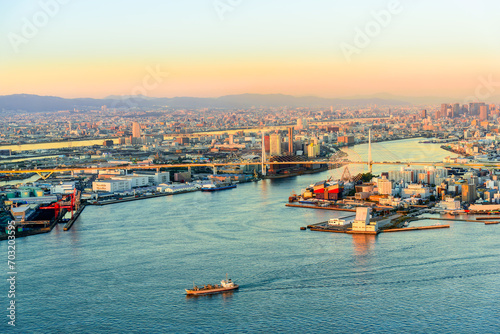Aerial sunset view of Osaka city at Osaka bay area with cargo port and boat. Japan architecture landscape background. photo