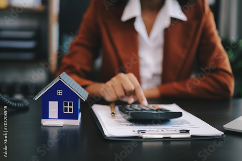 Real estate broker agent presenting and consult to customer to decision making sign insurance form agreement, home model, concerning mortgage loan offer .