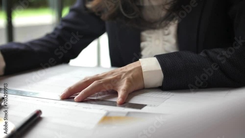 Woman architect working on drawing table. Female engineer or Architect working on blueprint. shot of young female architect drawing construction plan on paper while working in office. photo