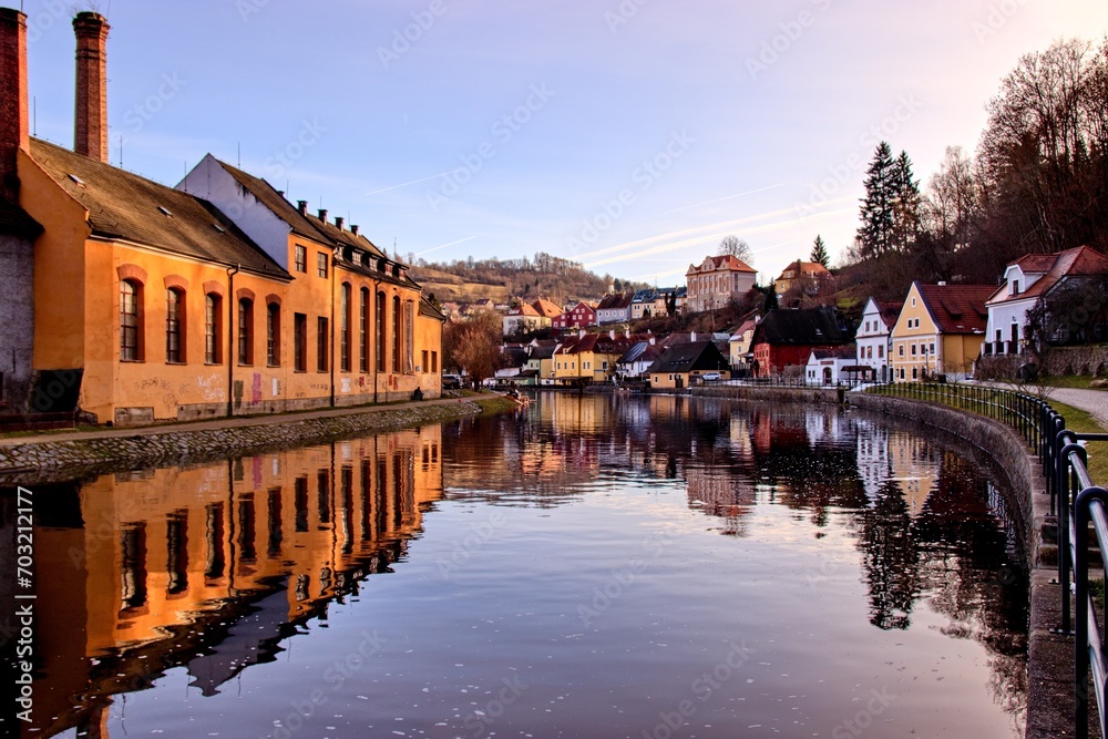 A view to the calm surface of Vltava river with water reflection of historical city Cesky Krumlov, Czech republic