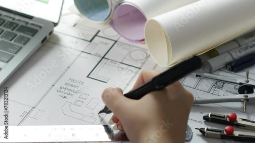 Female Architect working with blueprints for architectural plan, sketching a construction project concept. view of female hands architect drawing building plan with pencil concentrated on blueprint. photo