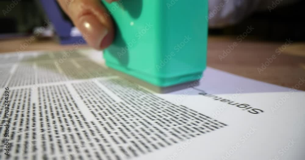 Agent female hands put approved stamp on document closeup