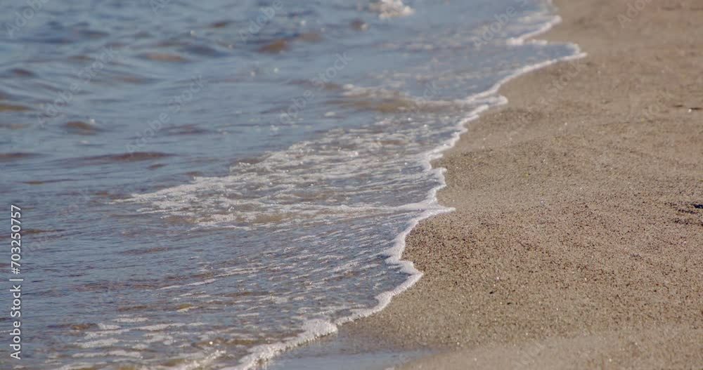Waves lapping onto shore. Slow motion shot of blue waves crashing on a sandy beach. Waves lapping onto shore. Slow motion shot of blue waves crashing on a sandy beach.