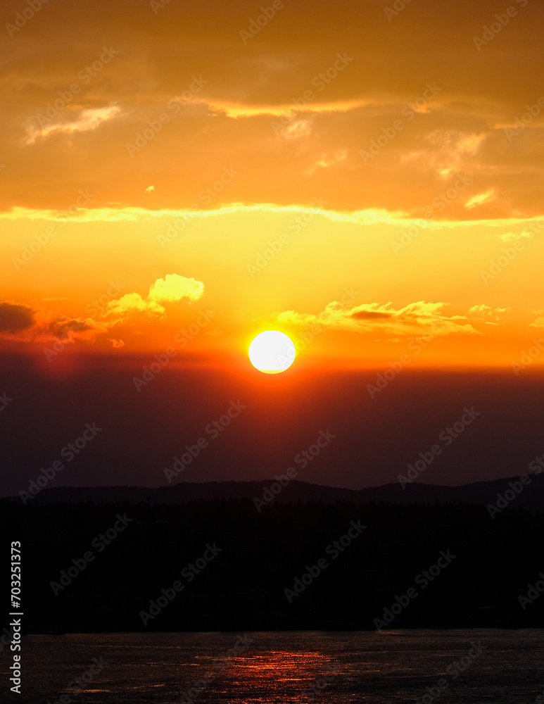 Panoramic sunrise or sunset landscape nature coastal scenery with beautiful fire sky and dramatic cloudscapes in Alaska Inside Passage glacier mountain range view