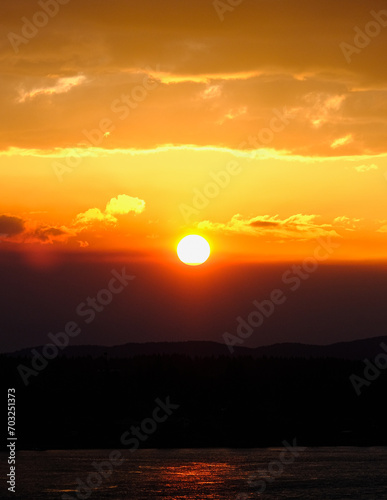 Panoramic sunrise or sunset landscape nature coastal scenery with beautiful fire sky and dramatic cloudscapes in Alaska Inside Passage glacier mountain range view