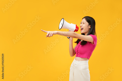 An Asian woman points forcefully with a megaphone, expressing urgency and assertiveness against a bold yellow background.
