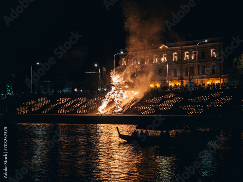 Vilnius, Lithuania - 09 22 2023: Celebrating the autumn equinox in Vilnius. Burning of a straw figure of a wolf on the Neris embankment near the King Mindaugas Bridge photo