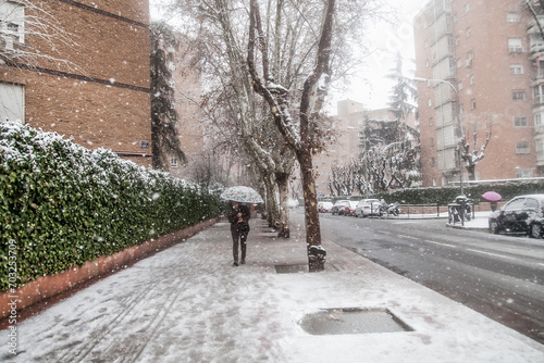 Persona caminando en la ciudad de 
Madrid nevando