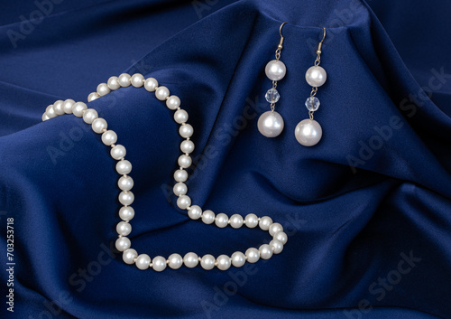Still life of blue drapery and pearl jewelry