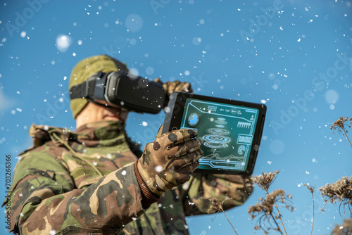 Modern technology in the army. Warfare analytic operator using vr virtual reality glasses checking coordination of the military team with tablet device augmented reality operating troops outdoors © TSViPhoto