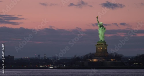 Statue of LIberty Towering Over Water of New York Bay After Sunset