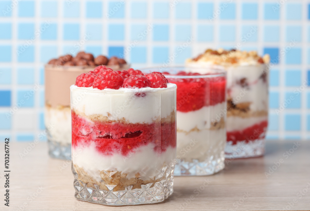 Homemade layered Desserts in a glass cups with yogurt, berries, cookie and chocolate balls on table Homemade layered Desserts in a glass cups with yogurt, berries, cookie and chocolate balls on table