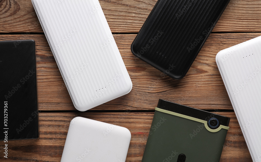 Power banks and external hard drives on wooden table Power banks and external hard drives on wooden table