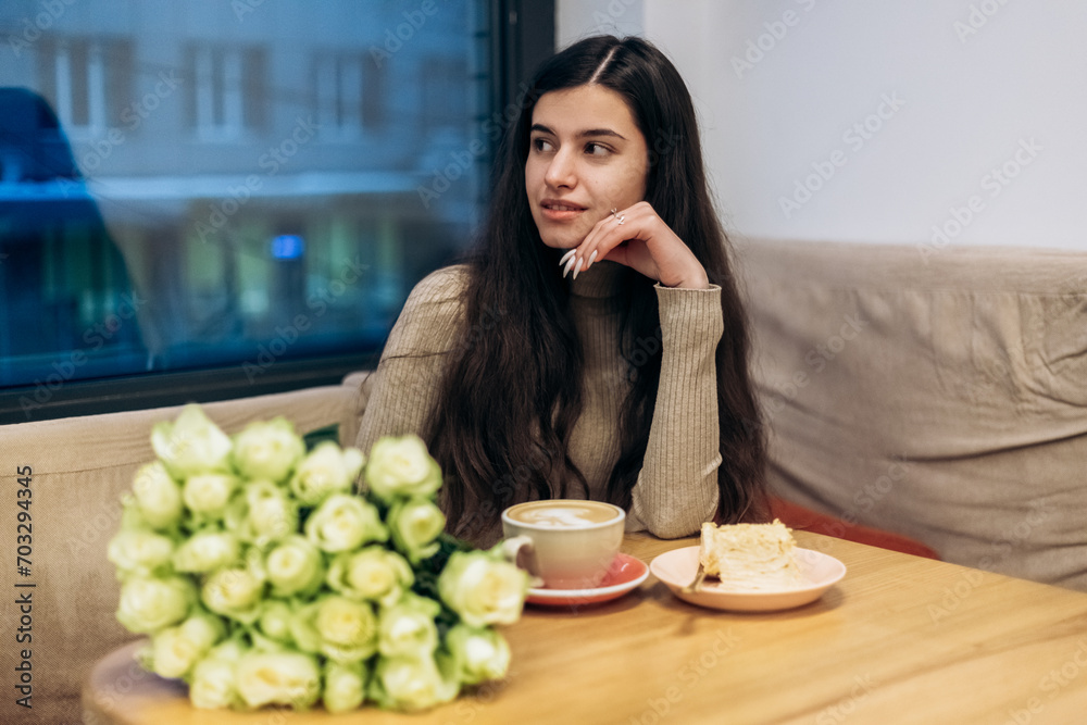 Pretty young woman sitting in cafe with bouquet of white roses, drink cup of coffee hot beverage, eating piece of creamy chocolate cake with nuts on plate, tasting dessert. Chill, relax, lunch
Pretty young woman sitting in cafe with bouquet of white roses, drink cup of coffee hot beverage, eating piece of creamy chocolate cake with nuts on plate, tasting dessert. Chill, relax, lunch
