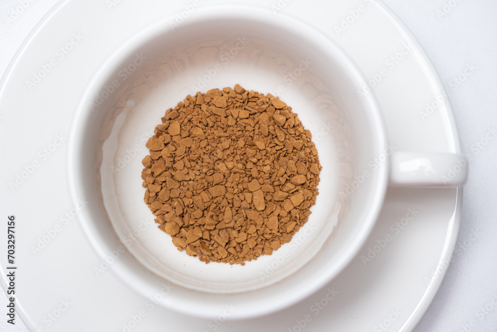 Freeze-dried instant granulated coffee in a cup on a white background close-up Freeze-dried instant granulated coffee in a cup on a white background close-up