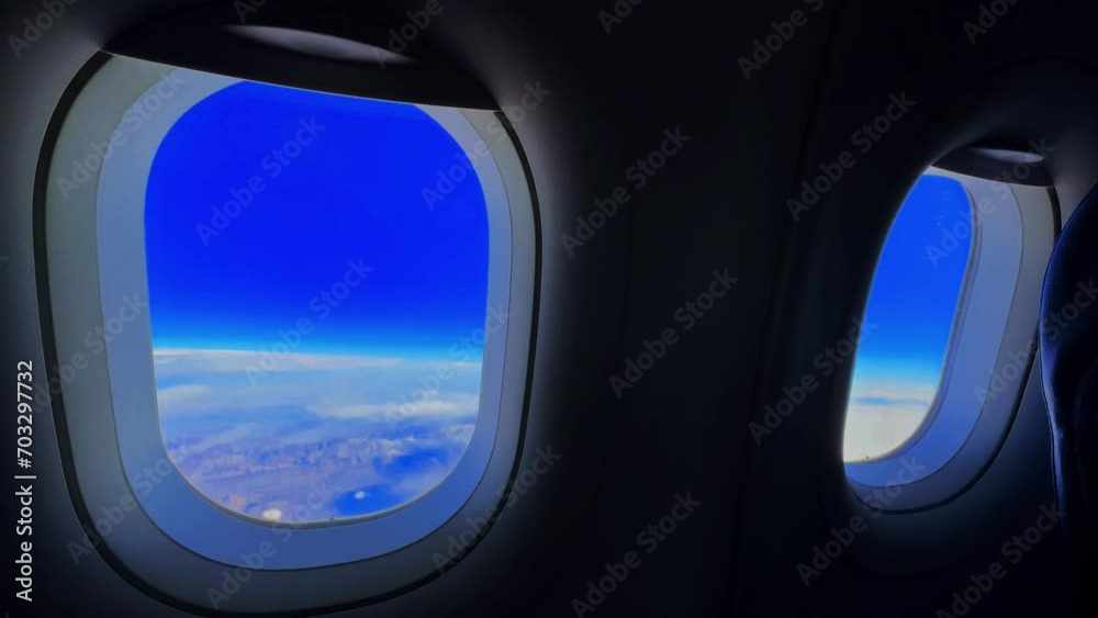 view from an airplane window, clear sky with clouds over the mountains, sky from an airplane window