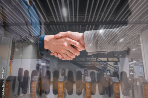 men or business people shaking hands with partner to greeting or dealing business joint venture with blurred entrace gates background photo