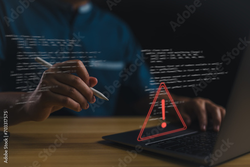 Staffs or Businessman, programmer, developer using computer laptop with triangle caution warning sign for notification error and maintenance concept. Virus detected warning, Cybercrime protection..