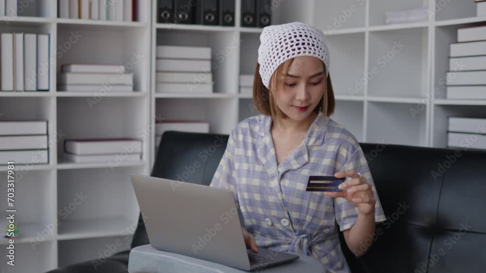 short hair woman is using credit card for shopping online on laptop at home.