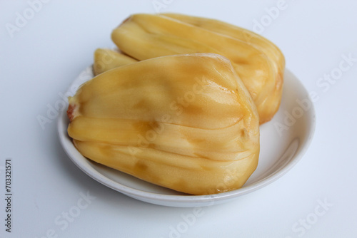 Yellow Jackfruit flesh from Artocarpus heterophyllus, on small white plate, isolated on white background