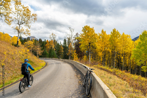 Tourist cycling on the Bow Valley Parkway in fall foliage season. Banff National Park, Canadian Rockies, Alberta, Canada. photo