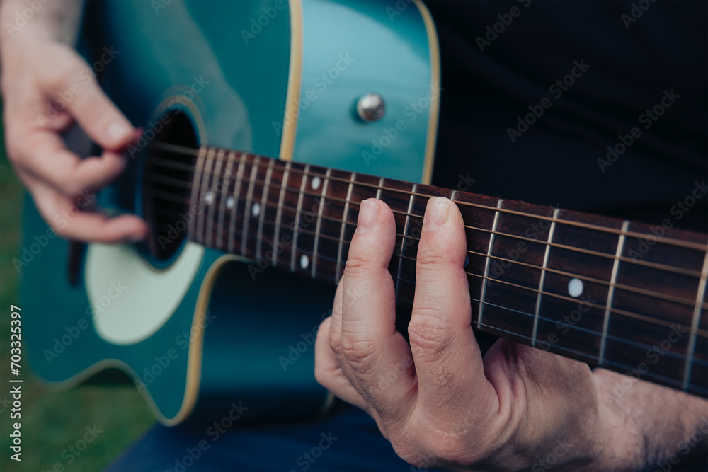 Close up of man's hands playing acoustic guitar. Musical instrument for recreation or hobby passion concept