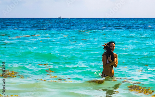 Pretty woman with dog on beach Playa del Carmen Mexico.