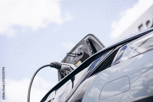 Electric car charging with a blue sky on background © Petro