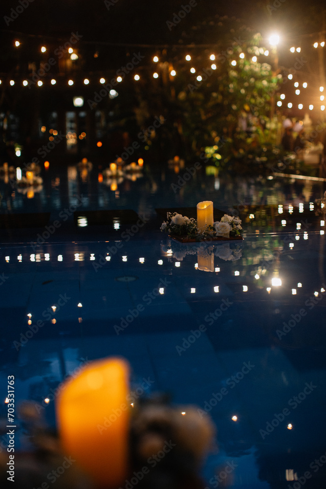 Outdoor Decoration for wedding event or avenue. Family dinner. Gathering. Engagement. Private party. Pool side. Drop lights. Floating candles. Table Setting. Center piece flowers. Night time.