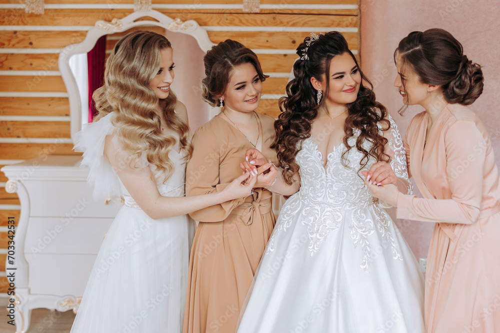 Friends rejoice with the bride in the morning. They take pictures, smile, help the bride fasten her dress. Friends rejoice with the bride in the morning. They take pictures, smile, help the bride fasten her dress.