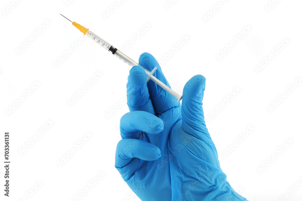 Vaccination syringe and hand in blue surgical glove Vaccination syringe and hand in blue surgical glove