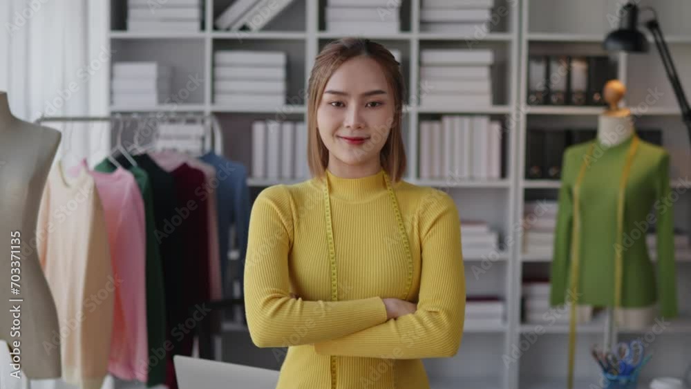 Female dressmaker designer is dress shop business owner standing and and crossed her arms in clothes workspace shop. Female dressmaker designer is dress shop business owner standing and and crossed her arms in clothes workspace shop.