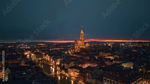Aerial helicopter hyper lapse view of Strasbourg Cathedral of Notre Dame illuminated and Petite France old french buildings architecture with beautiful night sky view photo