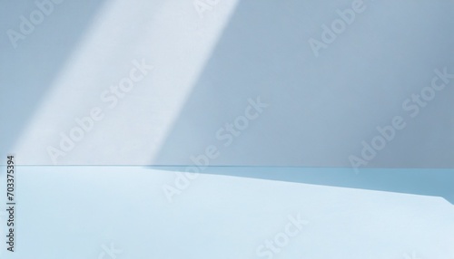 light minimalist geometric background image in gray and light blue tones with light and shadow from window for product presentation
