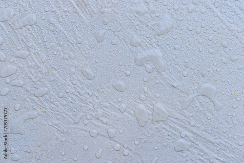 Large raindrops on wet white tile stone background
