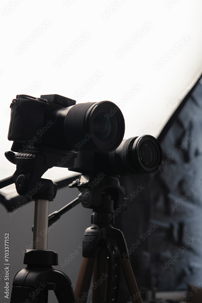 Video cameras on tripods, selective focus, Studio soft box, light. Filming, work of a videographer. hardware Radio microphone, receiver, directional microphone. Vertical photo