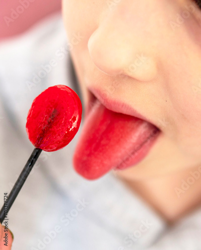 a child licks red candy,