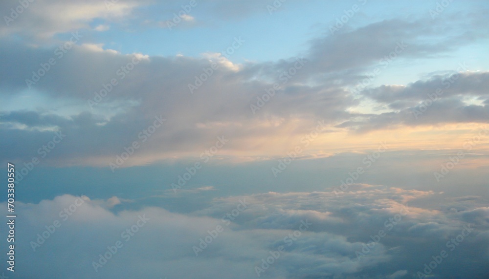 beautiful pastel cloudscape fluffy clouds in the sky horizon from a plane weather and overcast dawn