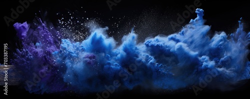 Explosion of indigo blue colored powder on black background photo