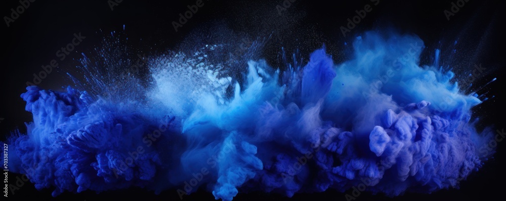 Explosion of indigo blue colored powder on black background