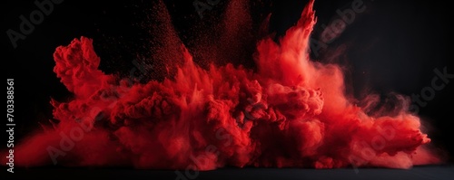 Explosion of crimson red colored powder on black background