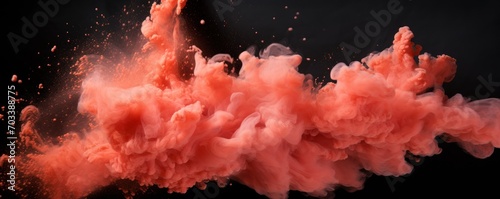 Explosion of coral colored powder on black background