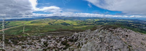 A panoramic view from the Great Sugar Loaf reveals the Wicklow Mountains in all their sprawling grandeur, a tapestry of peaks and valleys beneath the vast sky.