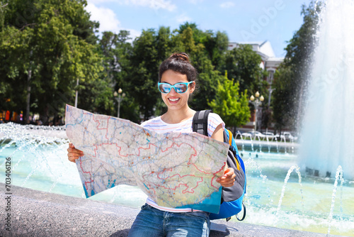 Tourist woman searching direction on location map photo