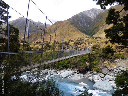 View over bridge on Rob Roy track, route to Rob Roy glacier near Wanaka in Mt. Aspiring national park, South Island of New Zealand. Bridge over a river and mountains in the background. photo